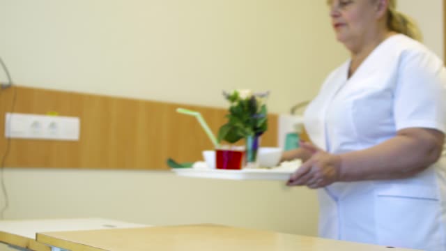 Krankenschwester-bringen-Essen-für-Patienten-in-einem-Krankenzimmer