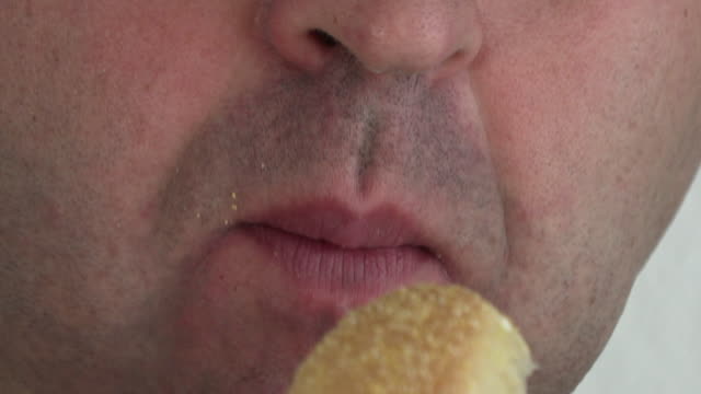 Young-man-eating-hamburger,-close-up
