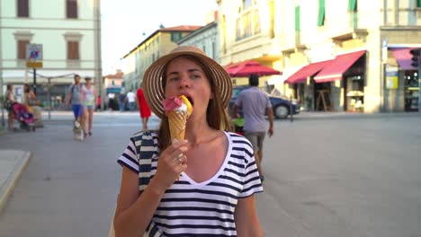 Piombino,-Livorno,-Toscana,-Italia.-Una-chica-es-caminando-por-la-calle-comiendo-un-helado