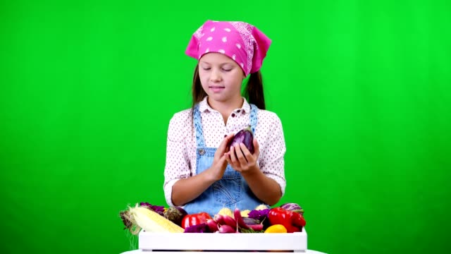 cute,-smiling,-little-farmer-girl-shows-a-box-with-different-fresh-vegetables,-harvest.-on-green-background-in-studio.-Healthy-food-to-your-table,-Healthy-nutrition