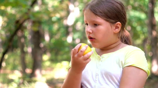 Kleine-Mädchen-Porträt-essen-Apfel-im-freien-Apfel-an-einem-Sommertag