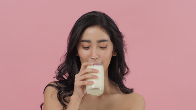 Mujer-asiática-atractiva-bebiendo-leche.