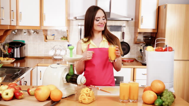 Mujer-en-la-cocina-bebiendo-zumo-de-naranja-4K