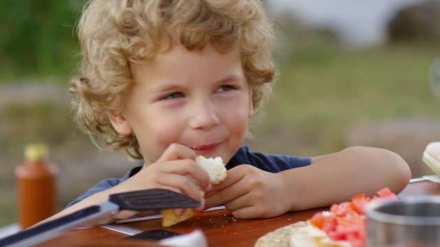 Niño-comer-la-comida-en-Picnic