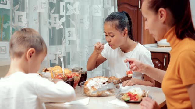 Family-dinner.-Mom,-daughter-and-son-have-dinner-together-in-the-kitchen
