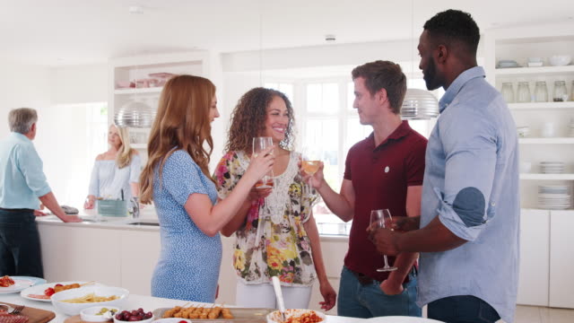 Group-of-family-and-friends-meeting-for-lunch-party-in-kitchen---shot-in-slow-motion