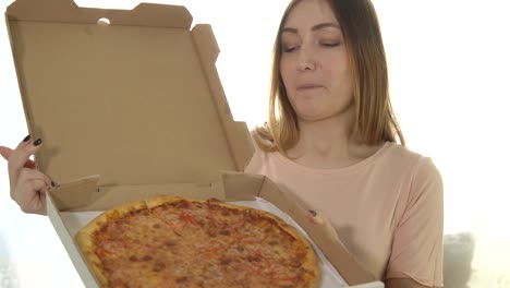 Mujer-joven-feliz-con-la-pizza-caliente-en-fondo-blanco.