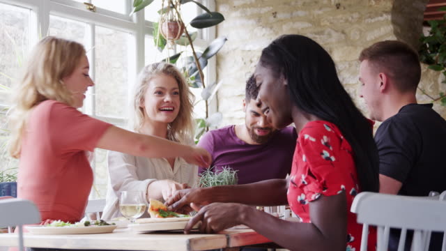 Amigos-adultos-jóvenes-multiétnicas-compartir-tapas-en-almuerzo-junto-a-una-mesa-en-el-restaurante,-bajo-ángulo