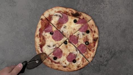 Mano-del-hombre-cortando-la-pizza