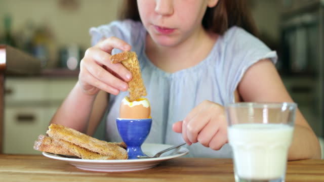 Nahaufnahme-von-Mädchen-essen-gesunde-gekochtes-Ei-und-braun-Toast-zum-Frühstück-In-der-Küche