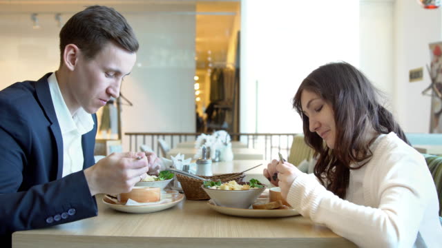 Hombre-joven-y-mujer-almorzando-en-un-café