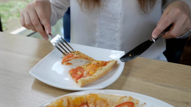 Brünette-Frau-in-einem-Café-Pizza-essen.-Schnelle-und-ungesunde-Ernährung