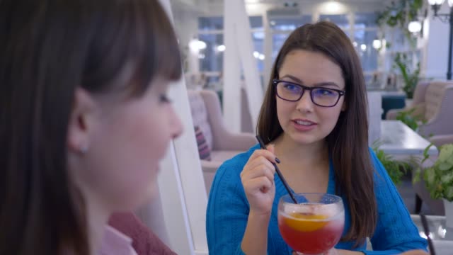 fröhliche-Freunde-Frauen-in-Gläsern-zu-kommunizieren-und-trinken-Cocktails-mit-Strohhalm-in-der-Mittagspause-im-Café-am-Wochenende