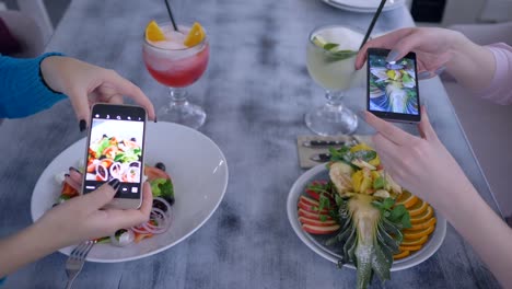 dulce-partido,-amigas-utilizan-modernas-tecnologías-móviles-y-tomar-fotografías-del-hermoso-alimento-para-medios-de-comunicación-social-durante-la-cena-sana-en-café