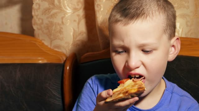 hungry-kid-eating-piece-of-pizza
