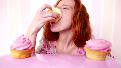 Joven-mujer-comiendo-cabezal-rojo-es-cupcakes-en-cámara-lenta
