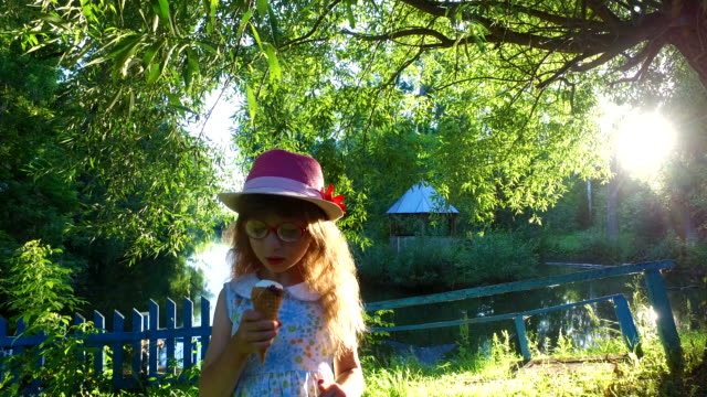 Little-girl-with-long-hair-eats-ice-cream-in-the-park.