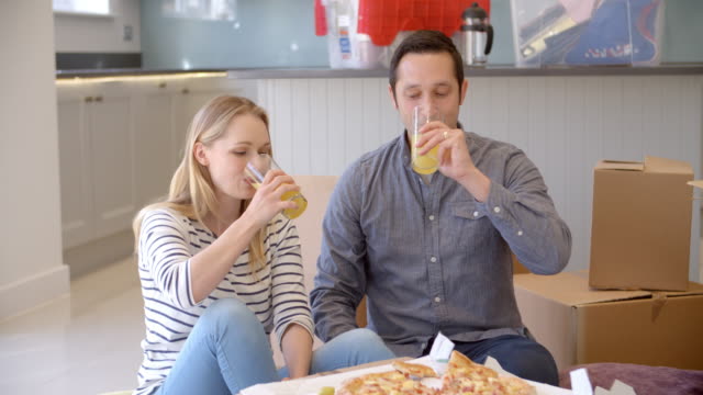 Paar-feiert-Umzug-in-neues-Zuhause-mit-Pizza