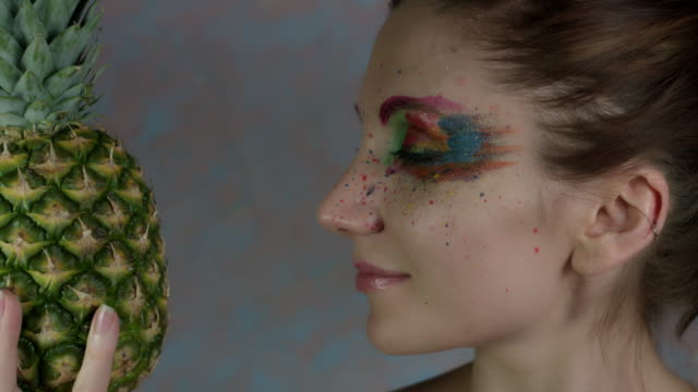 4k-Shot-of-a-Woman-with-Multicoloured-Make-up-with-Pineapple