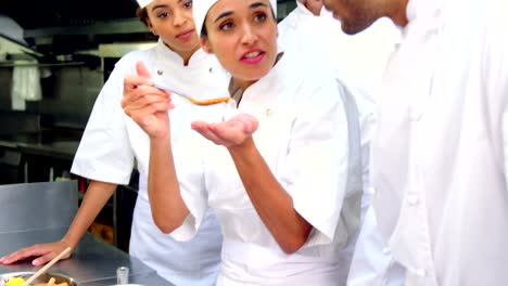 Team-of-chefs-tasting-food-in-the-kitchen