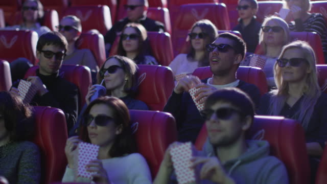Grupo-de-personas-en-gafas-3d-están-viendo-una-película-en-un-cine-de-película.