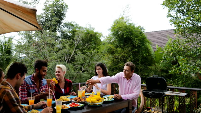 Passanten-Essen-Essen-auf-der-Terrasse-jungen-Freunde-sprechen,-sitzen-am-Tisch-im-freien-Kommunikation