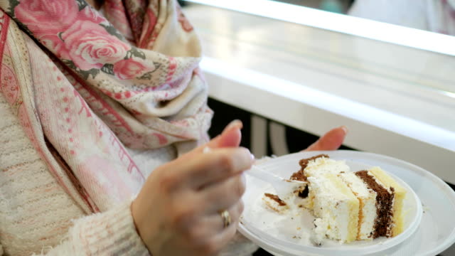 Schöne-Frau-in-Gläsern-isst-verführerisch-Kuchen-mit-Sahne,-close-up-von-Mädchen-genießen-frischen-Kuchen,-Plastikgeschirr-mit-Dessert-in-der-hand