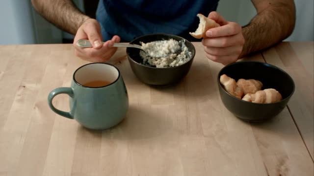 Hombre-comiendo-gachas-y-croissants-para-el-desayuno