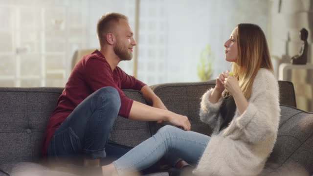Cheerful-couple-at-home-on-couch