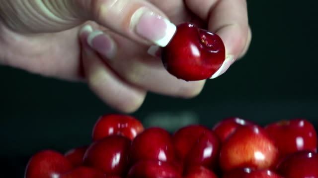 Lips-and-cherries.-The-girl-takes-and-bites-a-ripe-cherry-berry-from-the-stalk