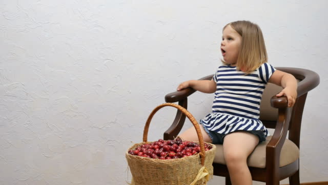 Kleines-Mädchen-Drossel-auf-einen-Kirschkern-bei-der-Nahrungsaufnahme-der-Beere