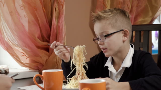Niedlicher-kleine-Junge-isst-Spaghetti-in-der-Küche