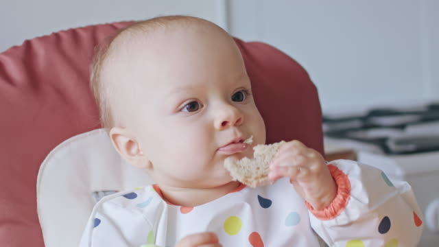 A-Baby-Girl-Eating-Bread-at-Home