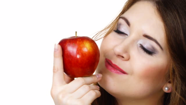 Frau-hält-Apfelfrucht-nah-zu-Gesicht