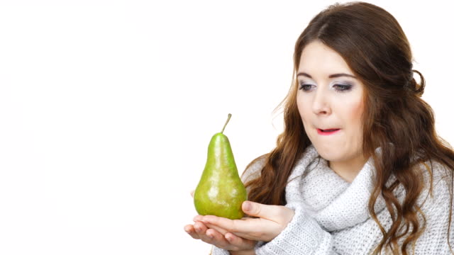Woman-holds-pear-fruit,-licking-lips-isolated
