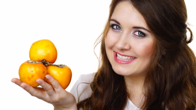 Cheerful-woman-holds-persimmon-kaki-fruits,-isolated