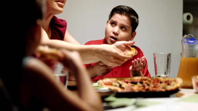 Madre-dando-ensalada-en-lugar-de-Pizza-al-sobrepeso-hijo