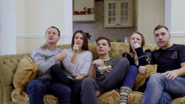 Gruppe-von-Freunden-Uhren-Film-zu-Hause-und-Essen-popcorn