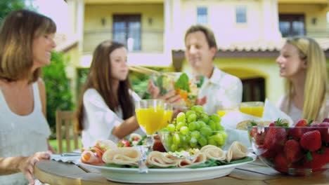 Junge-Familie-im-Freien-zu-Speisen,-auf-gesunde-frische-Salat