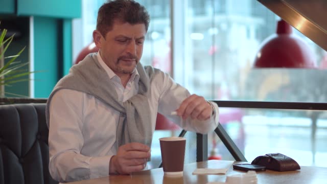 Erwachsener-Mann-in-einem-weißen-Hemd-hinzugefügt-frisch-gemachten-Kaffee-Zucker.