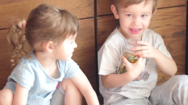 Kinder-versuchen,-öffnen-Sie-Glas-mit-bunten-Bonbons