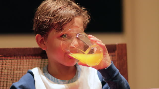 Nahaufnahme-des-jungen-Orangensaft-trinken.-Kind-einen-Schluck-der-Hydratation