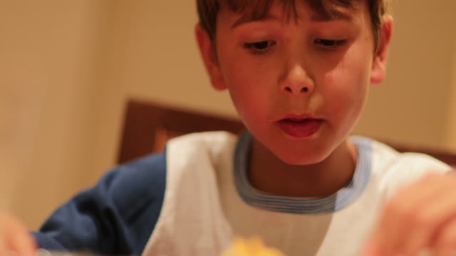 Niño-expresivo-comer-espaguetis-fideos-para-la-cena.-Expresiones-divertidas-exagerados-de-joven-disfrutar-de-pasta-para-la-cena
