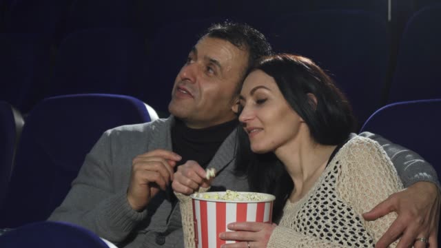 Mature-happy-couple-enjoying-their-date-at-the-cinema-watching-a-movie
