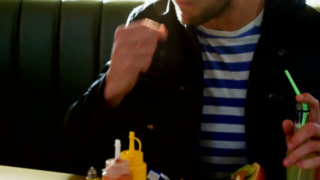 Man-drinking-juice-while-having-french-fries-4k