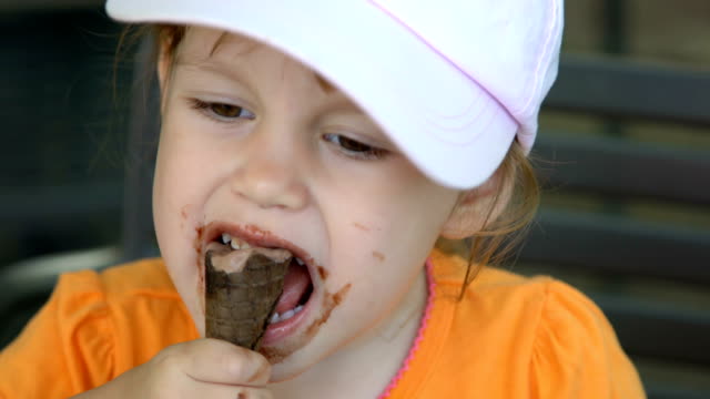 Closeup-of-little-girl-eating-ice-cream-and-smiling