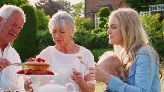 Grandparents-Have-Afternoon-Tea-With-Grandson-And-Adult-Daughter
