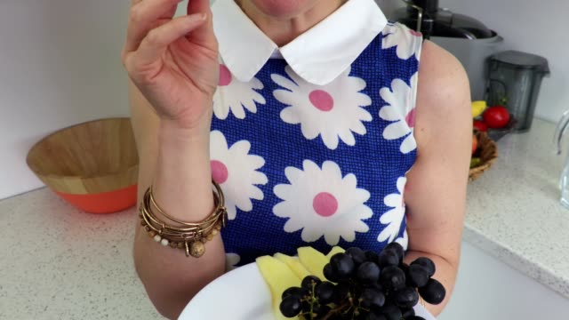 Woman-eats-apple-cloves-and-grapes.Vegetarian-concept