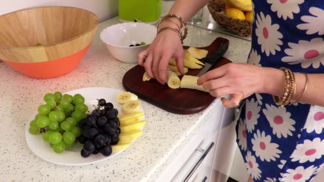 Frau-legt-auf-einen-Teller-mit-Bananenscheiben