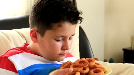 Jungen,-die-in-Ringe-geschnittenen-Zwiebeln-Essen